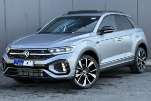 Volkswagen T-Roc gris pyrite en 3/4 avant droit avec jantes alliage 19" et toit ouvrant ouvert.