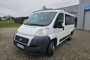 Fiat Ducato Combi blanc vu en 3/4 avant droit, fourgon 9 places avec pare-chocs noir et calandre distinctive.