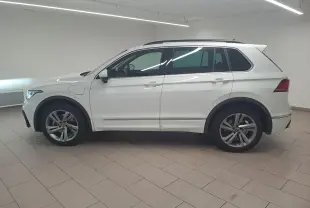 Volkswagen Tiguan 1.4 eHybrid R-Line blanc pur vu de profil côté gauche en intérieur showroom.