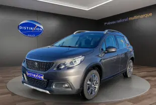 Peugeot 2008 gris platinium en 3/4 avant droit, avec calandre noire et jantes alliage visibles en showroom.