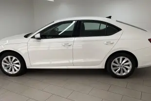 Profil côté gauche d'une Skoda Octavia blanc candy 2024 avec jantes alliage et feux arrière allumés.