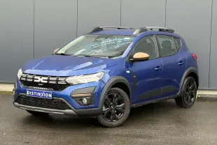 Dacia Sandero Stepway Bleu Iron en 3/4 avant droit avec jantes noires et coques de rétroviseurs cuivrées.
