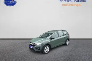 Dacia Jogger vert 3/4 avant droit avec barres de toit et signature lumineuse en Y à LED visible.