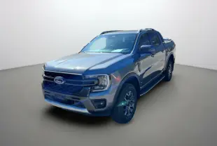 Ford Ranger 2.0 205 Wildtrak Plus gris carbone vu en 3/4 avant droit avec barres de toit et jantes alu 18 pouces.