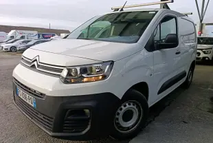 Vue 3/4 avant droit d’un Citroën Berlingo blanc 2020 avec calandre noire et barres de toit métalliques.