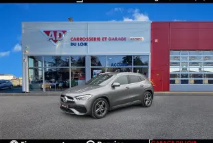Mercedes GLA 220 d AMG Line gris vu de profil côté gauche devant un garage avec façade blanche et rouge