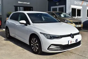 Volkswagen Golf blanche vue en 3/4 avant droit, avec jantes stylisées et phares LED modernes.