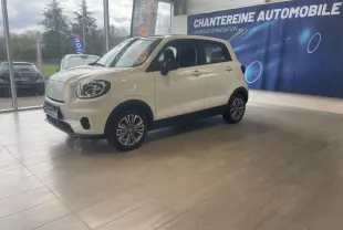 Vue 3/4 avant droite du Leapmotor T03 électrique blanc avec toit noir, dans un showroom lumineux.