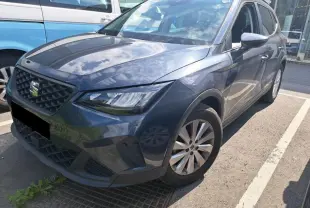 SEAT Arona gris magnétique vu en 3/4 avant droit, mettant en valeur ses phares EcoLED et sa calandre distinctive.