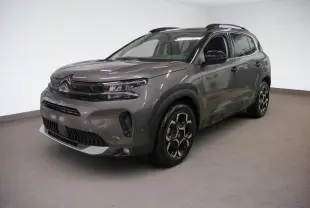 Citroën C5 Aircross Hybrid gris Platinium en 3/4 avant droit, avec jantes bi-ton et barres de toit noires.