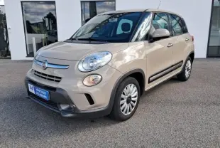 Fiat 500L beige vue 3/4 avant droit, avec phares ronds et protections noires sur les bas de caisse.