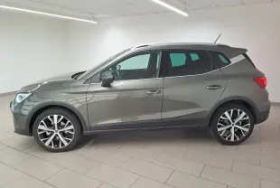 Vue de profil côté gauche d'un SEAT Arona gris falaise 2024 avec jantes alliage 18'' et vitres arrière surteintées.