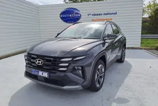 Hyundai Tucson 2025 gris Ecotronic en 3/4 avant droit, avec calandre noire et jantes bi-ton visibles.