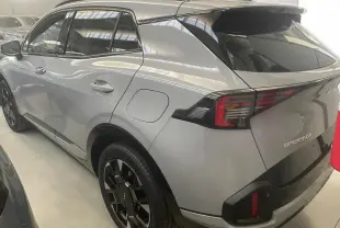 Vue 3/4 arrière droite du KIA Sportage 2026 hybride gris loup avec jantes noires et feux arrière LED distinctifs.