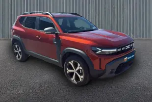 Vue 3/4 avant droit d'un Dacia Duster orange 2025 avec barres de toit et jantes alliage 18 pouces.