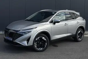 Nissan Qashqai 2024 gris métallisé en 3/4 avant droit avec jantes alliage noires et toit blanc.