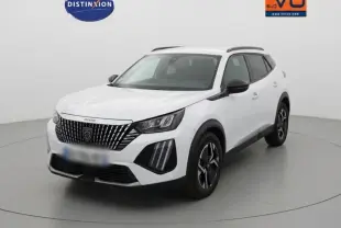 Peugeot 2008 blanc en 3/4 avant droit, avec barres de toit et jantes alliage 17 pouces visibles.