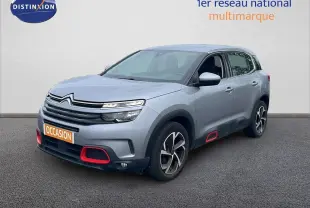 SUV Citroën C5 Aircross gris clair métal vu en 3/4 avant droit avec détails rouges sur pare-chocs et bas de porte.