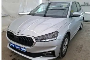 Vue 3/4 avant droite d'une Skoda Fabia Ambition gris clair 2023 avec calandre noire et phares LED allumés.