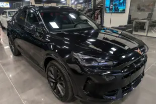 Vue 3/4 avant droite d'un CUPRA Formentor eHybrid noir minuit, avec jantes noires et intérieur sombre visible.