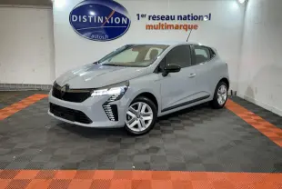 Renault Clio gris clair vue 3/4 avant droit dans un showroom avec éclairage et logo Distinxion en arrière-plan