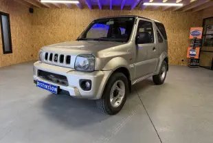 Suzuki Jimny Cabriolet gris en 3/4 avant droit, avec hard-top et jantes alu visibles en intérieur showroom.