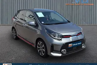 Vue 3/4 avant d'une KIA Picanto gris anthracite 2023 avec détails rouges sur la calandre et jantes alliage.