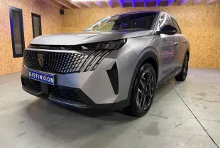 Peugeot 3008 1.2 Hybrid 136 Allure gris en 3/4 avant droit, avec calandre noire et jantes alliage distinctives.