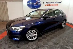 Audi A3 bleu 3/4 avant droit dans un showroom avec jantes alliage et phares LED allumés.