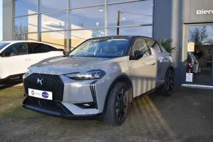 DS3 Crossback gris 3/4 avant droit avec toit noir, calandre distinctive et jantes noires, devant un showroom.