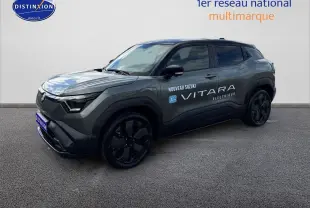 Suzuki Vitara électrique 2026 en 3/4 avant, couleur gris foncé avec toit noir et jantes noires distinctives.