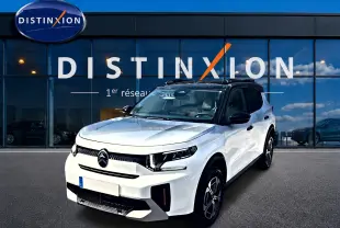 Citroën C3 Aircross blanc vue 3/4 avant droit, avec toit noir et jantes alu distinctives, devant vitrine Distinxion.