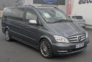 Mercedes Viano gris en 3/4 avant droit avec jantes alliage et vitres arrière surteintées, stationné devant un garage