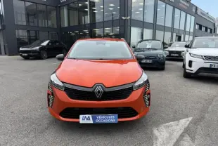 Vue de face d'une Renault Clio V SCE 65 Evolution orange vif, avec calandre noire et feux LED verticaux allumés.