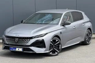 Peugeot 308 gris Artense en 3/4 avant droit, avec calandre distinctive et jantes alliage bi-tons.