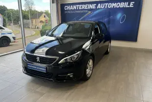 Peugeot 308 noire vue en 3/4 avant droit dans un showroom avec bannière Chantreine Automobile en arrière-plan.
