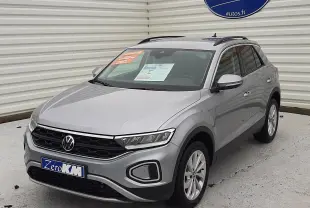 Volkswagen T-Roc gris pyrite métal en 3/4 avant droit, avec calandre noire et toit ouvrant visible.