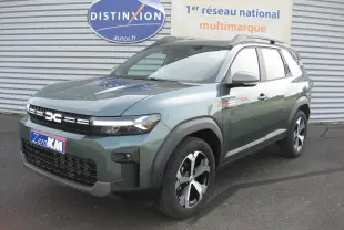 Dacia Bigster gris schiste en 3/4 avant droit, SUV hybride avec calandre noire et jantes modernes.