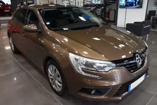 Renault Mégane IV TCe 100 Life brun capuccino vue 3/4 avant en intérieur avec phares et calandre distinctifs.