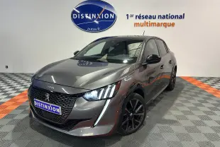 Peugeot 208 BlueHDi gris en 3/4 avant droit avec toit panoramique et feux LED allumés dans un showroom