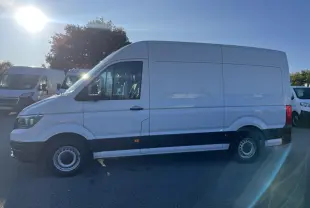 Vue latérale droite d'un Volkswagen Crafter blanc 35 L3H3 avec jantes acier et pare-chocs noirs sur parking.