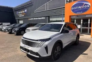 Peugeot 5008 Hybrid blanc Okénite en 3/4 avant droit, avec calandre distinctive et jantes alu, devant un concessionnaire.