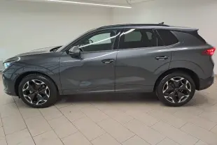 Vue de profil côté gauche d'un CUPRA TERRAMAR gris Timanfaya avec jantes 19'' Cosmic usinées dans un intérieur lumineux.