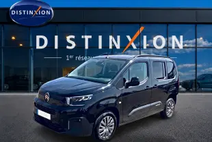 Citroën Berlingo noir vue 3/4 avant droit, avec barres de toit et poignées ton carrosserie visibles.