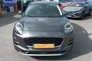 Vue avant d'une Ford Puma gris foncé métal avec calandre noire et plaque "OCCASION" orange visible.