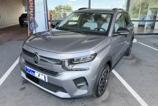 Citroën E-C3 113 MAX gris Mercury en 3/4 avant droit, avec jantes alliage 17 pouces et intérieur clair visible.