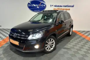 Volkswagen Tiguan noir métal 2015 en 3/4 avant droit avec phares et antibrouillard allumés, toit ouvrant visible.
