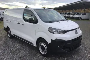 Fiat Scudo Fourgon blanc en 3/4 avant droit, avec pare-chocs noir et jantes acier, sur parking extérieur.