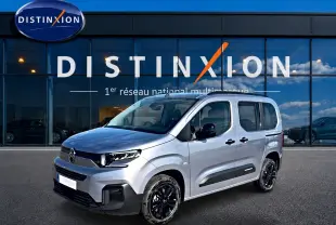 Vue 3/4 avant droit du Citroën Berlingo 2026 gris acier avec jantes noires et protections latérales noires.