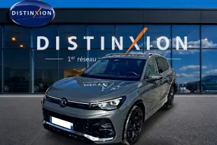 Volkswagen Tiguan 2.0 TDI gris dauphin en 3/4 avant droit, avec jantes noires et calandre R-Line visible.